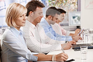 Businesswoman writing at business meeting