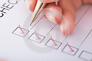 Businesswoman writing on checklist