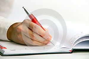 Businesswoman writing in a datebook