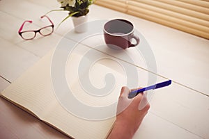 Businesswoman writing notes in book