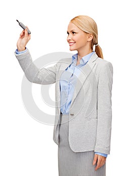 Businesswoman writing something in air with marker