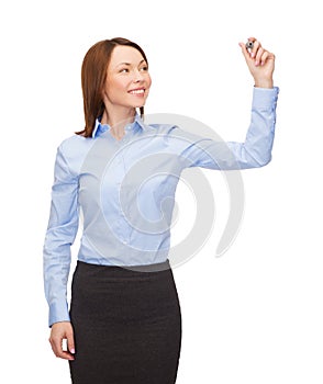 Businesswoman writing something in air with marker