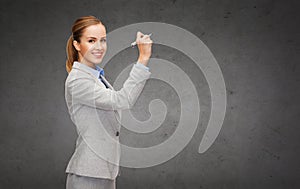 Businesswoman writing something in air with marker