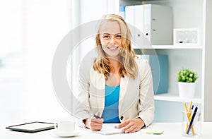 Businesswoman writing to notebook at office