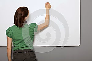 Businesswoman writing on whiteboard in office