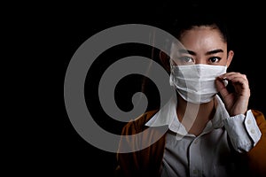 Businesswoman of young Asia woman putting on a respirator N95 mask to protect from airborne respiratory diseases as the flu covid-