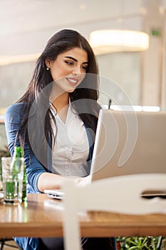 Businesswomen with coffee working at laptop in cafe