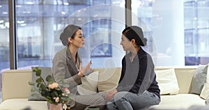 Businesswomen colleagues talking, met in office lobby during break