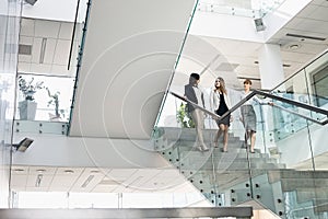 Businesswomen conversing while moving down steps in office