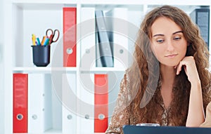 Businesswomen with digital tablet sitting in modern office background.