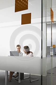 Businesswomen Discussing Over Laptop In Office