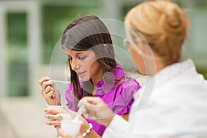 Businesswomen eating yogurt