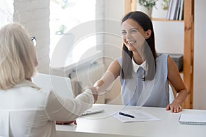 Businesswomen greets each other shake hands starting negotiations formal meeting