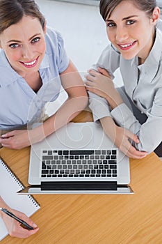 Businesswomen having a meeting and smiling up at camera