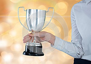 Businesswomen holding a trophy in a gold background