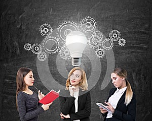 Businesswomen and light bulb with cogs