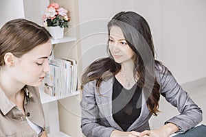Businesswomen looking keep an eye on her friend while working in office