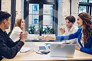 businesswomen shaking hands in office