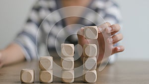 Businesswomen stack blank wooden cubes on the table with copy space, empty wooden cubes for input wording, and an infographic icon