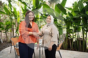 businesswomen handshake with her colleague in a cafe