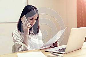 Businesswomen are using the phone to discuss business deals.