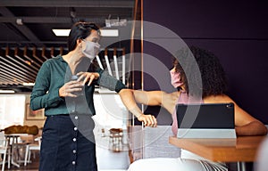 Businesswomen Wearing Masks Have Socially Distanced Meeting In Office Cubicle