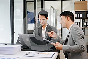 Businesswomen work and discuss their business plans. A Human employee explains and shows her colleague the results paper