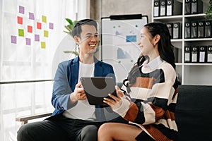 Businesswomen work and discuss their business plans. A Human employee explains and shows her colleague the results paper in modern