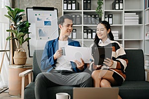 Businesswomen work and discuss their business plans. A Human employee explains and shows her colleague the results paper in modern