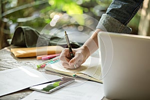 A businesswomen is working on desk office with her computer laptop and writing accounts for investment. interior design of