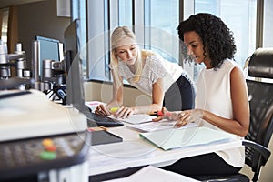 Businesswomen Working At Office Desk On Computer Together