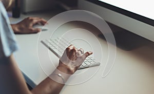 Businesswomen working at office with monitor computer, young hipster manager typing on keyboard, closeup finger female hands