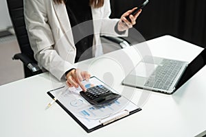 Businesswomen working with tablet and using a calculator to calculate the tax of static in office. Finance accounting concept