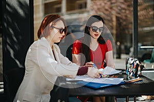 Businesswomen working together at an outdoor cafe in the city