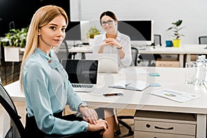 Businesswomen at workplace with laptops