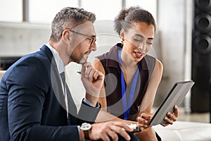 Busineswoman working on digital tablet with her boss