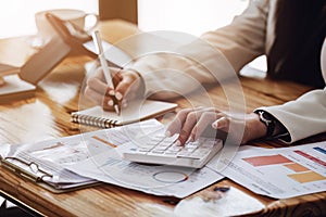 businss woman using calculator to calculating a sales and profit accounts on the report