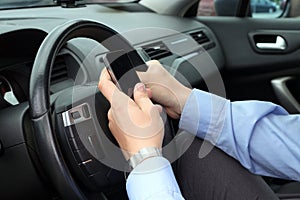 Businwssman using mobile phone while driving the car