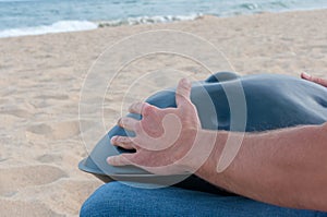 Busker sit on sand and play the Hang or handpan photo