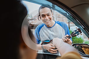 busker smiles when someone rewards from the car photo