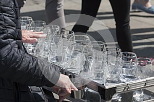 A busker, street performer, musician playing an unusual uncommon instrument made from wine glasses - glass harp