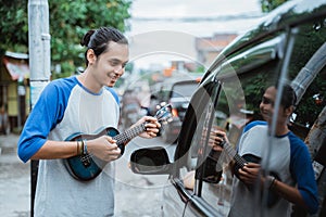 busker use musical instruments and sing beside a car photo