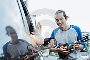 busker using a musical instrument and singing was rejected by someone from the car photo