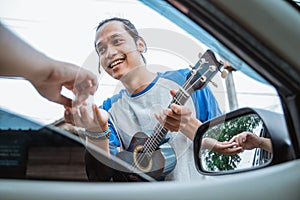 buskers feel happy when someone gives money from the car photo