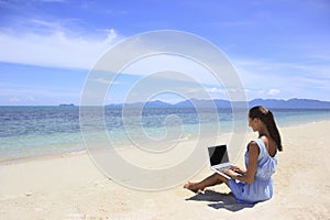 Bussines woman working on the beach with a laptop
