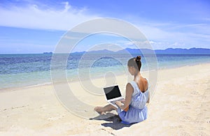 Bussines woman working on the beach with a laptop