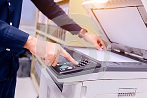 Bussiness man press button on panel of printer.