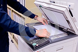 Bussiness man press button on panel of printer.