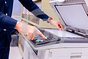 Bussiness man press button on panel of printer.