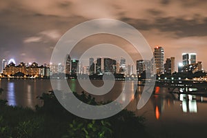 Bustling metropolis at night illuminated by bright lights, with a large lake in Singapore